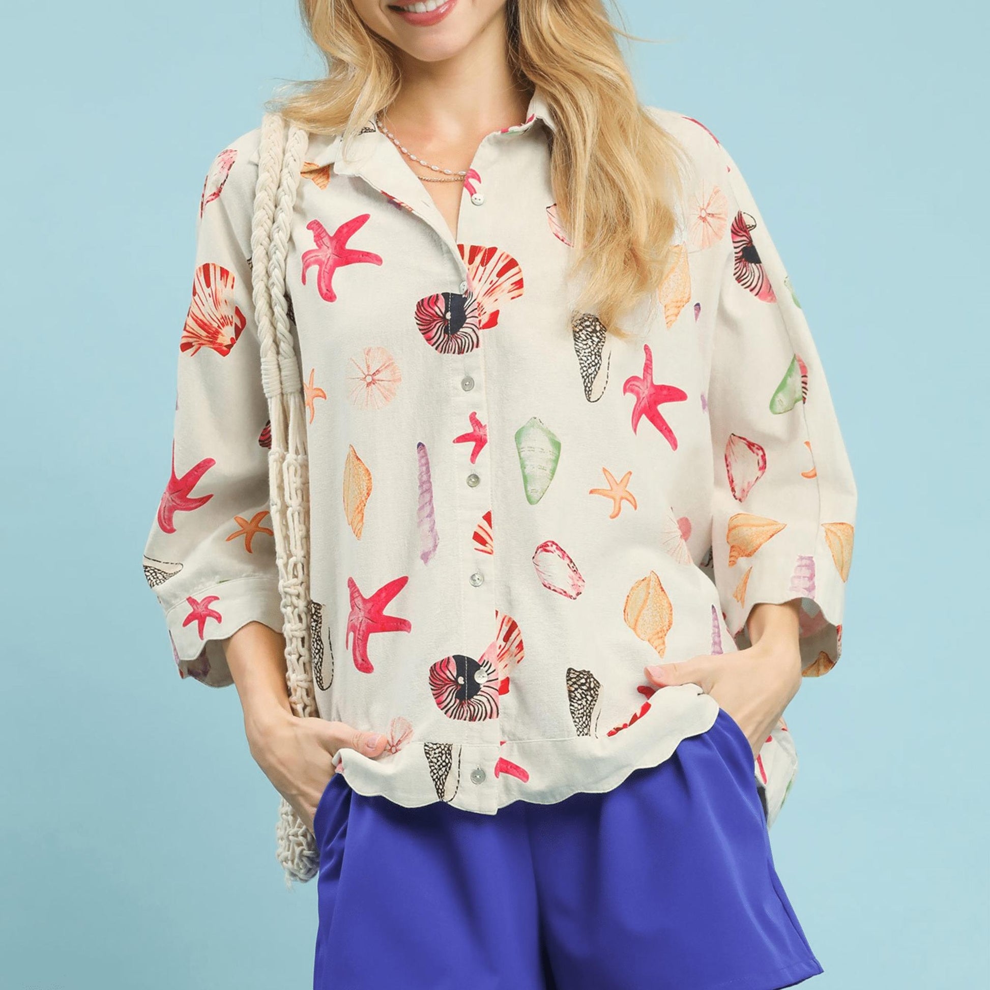 Front view of the Umgee seashell and starfish print button-down top in coral mix.