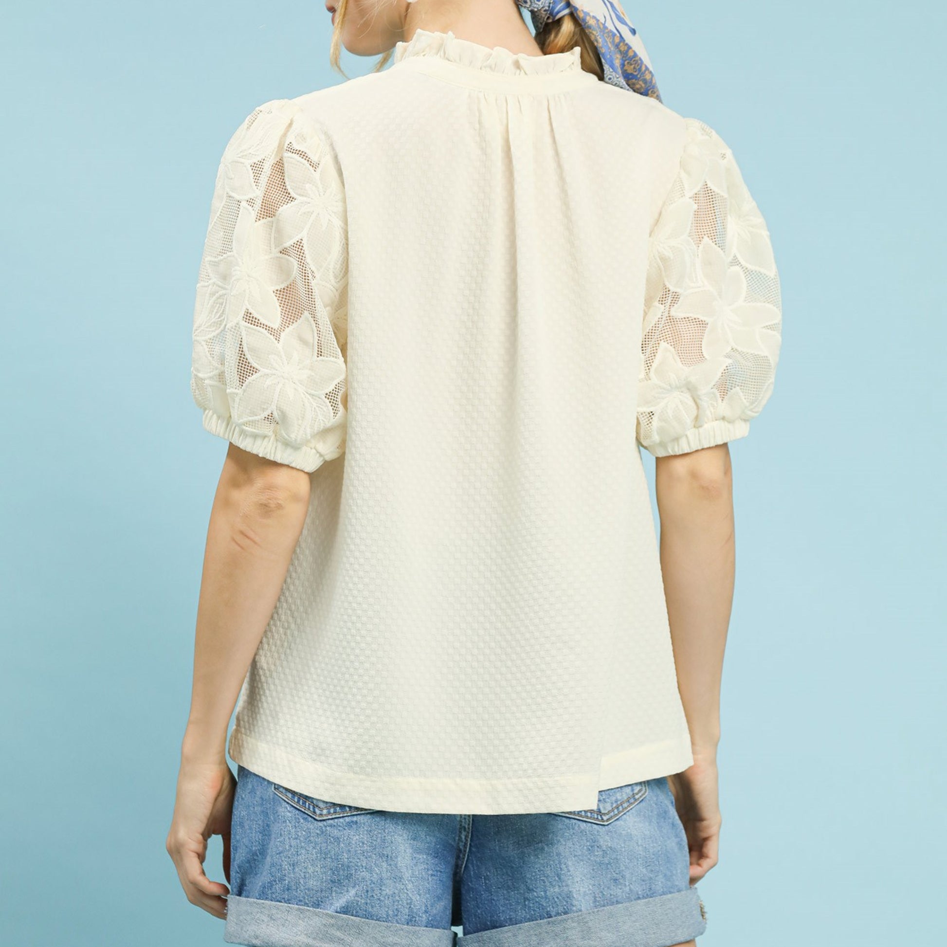 Back view of the textured cream blouse showing the relaxed and flowy silhouette.