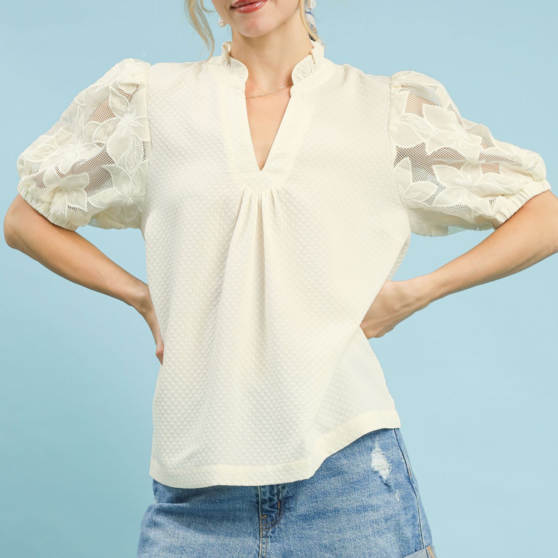 Lifestyle shot of the cream textured blouse with lace sleeves for an elegant outfit.