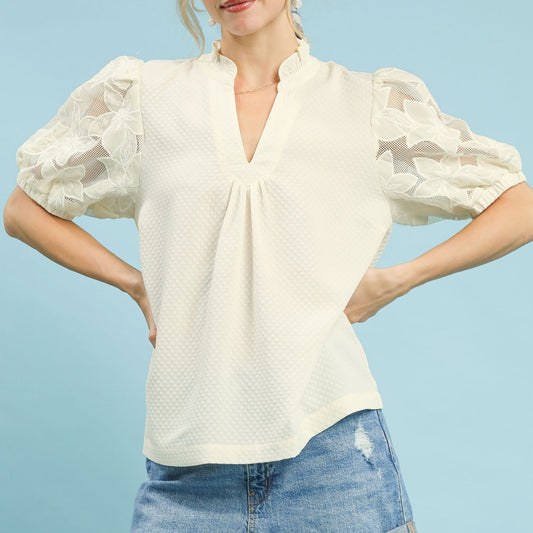 Lifestyle shot of the cream textured blouse with lace sleeves for an elegant outfit.