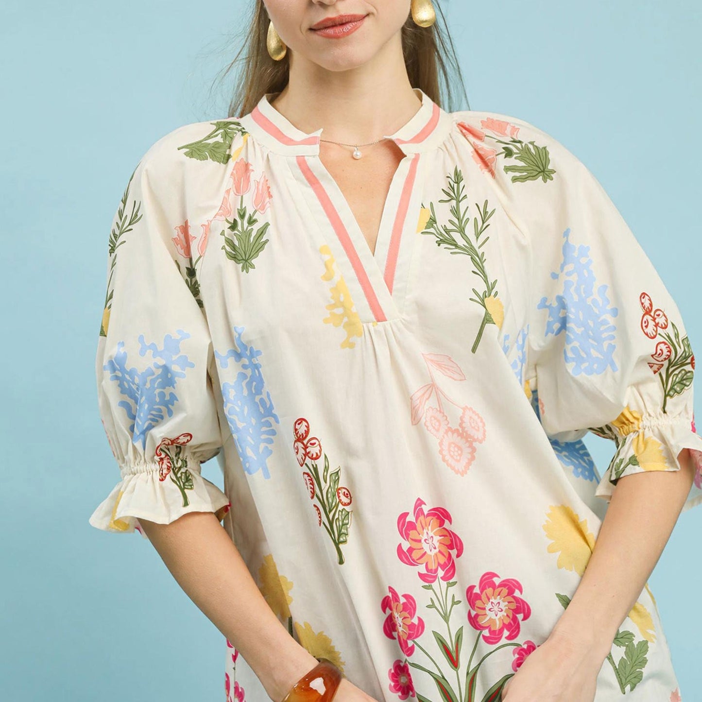 Front view of the Umgee floral split neck puff sleeve top in Cream featuring a botanical print.