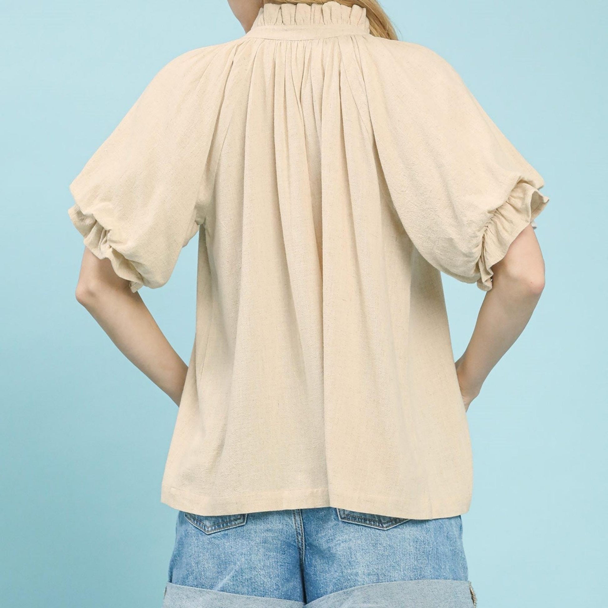 Back view of the women's oatmeal linen-cotton top highlighting the airy fabric.