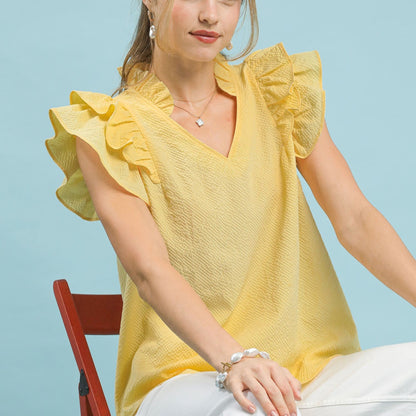 Front view of the Umgee textured ruffle sleeve V-neck blouse in ice lemon.