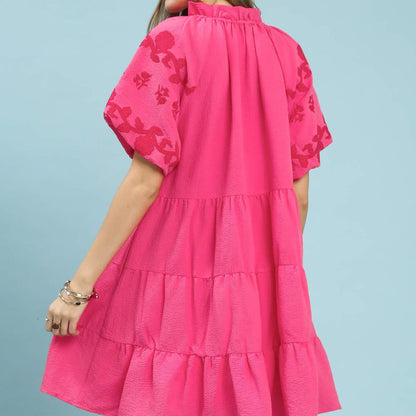 Pink dress with floral embroidery on a solid background