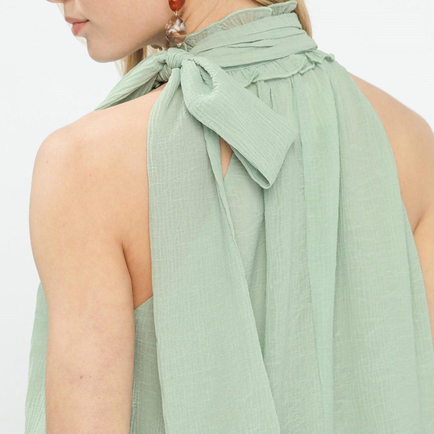 Close-up of the adjustable tie-neck and back keyhole on the Umgee mint chiffon blouse.