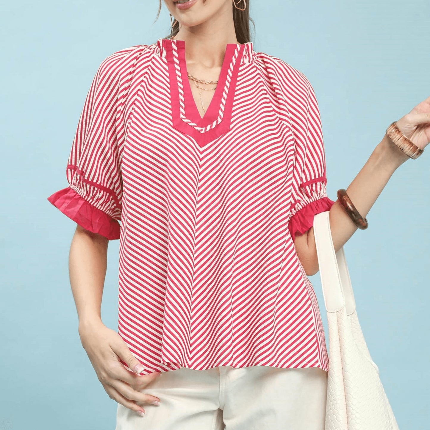 Front view of the Umgee stripe ruffle sleeve split-neck blouse in raspberry pink.