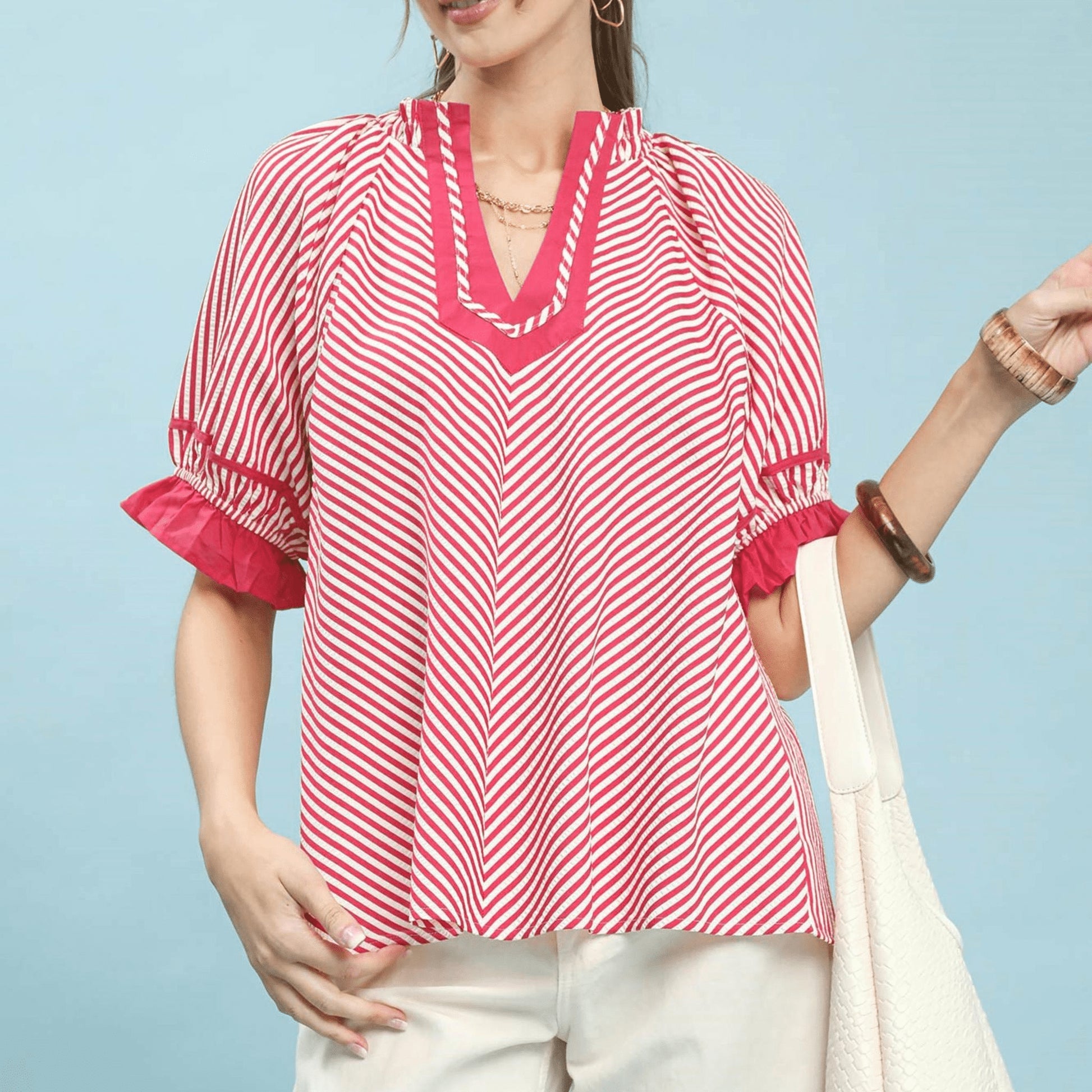 Front view of the Umgee stripe ruffle sleeve split-neck blouse in raspberry pink.