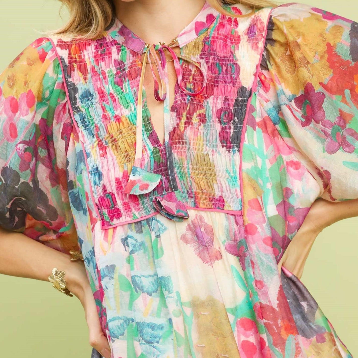 Close-up of the smocked V-neckline and contrast stitching on the floral Tencel dress.