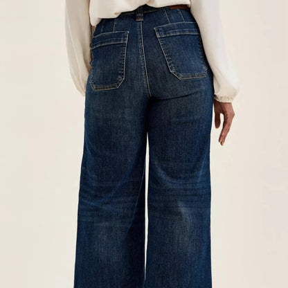 Back view of dark wash utility jeans with structured patch pocket design.
