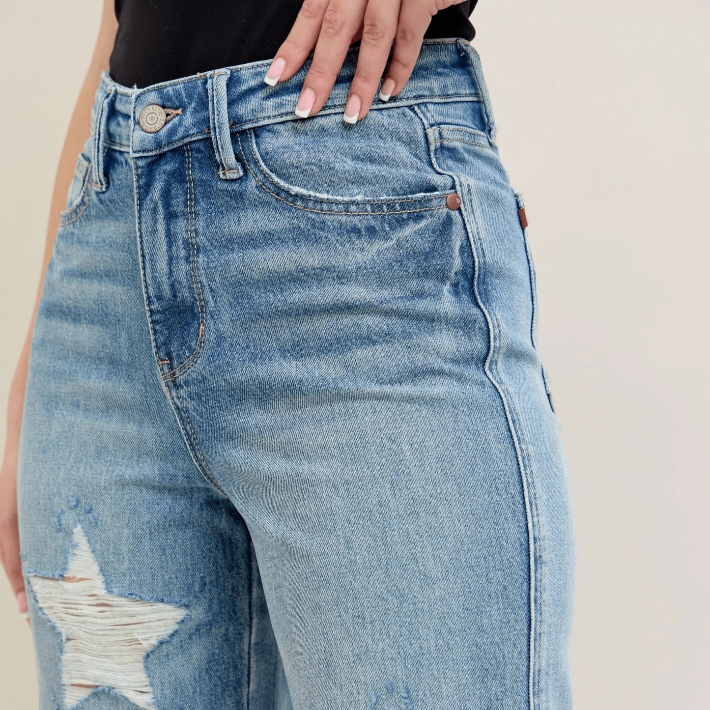 Styling shot of star-shaped destroy 90s straight jeans.