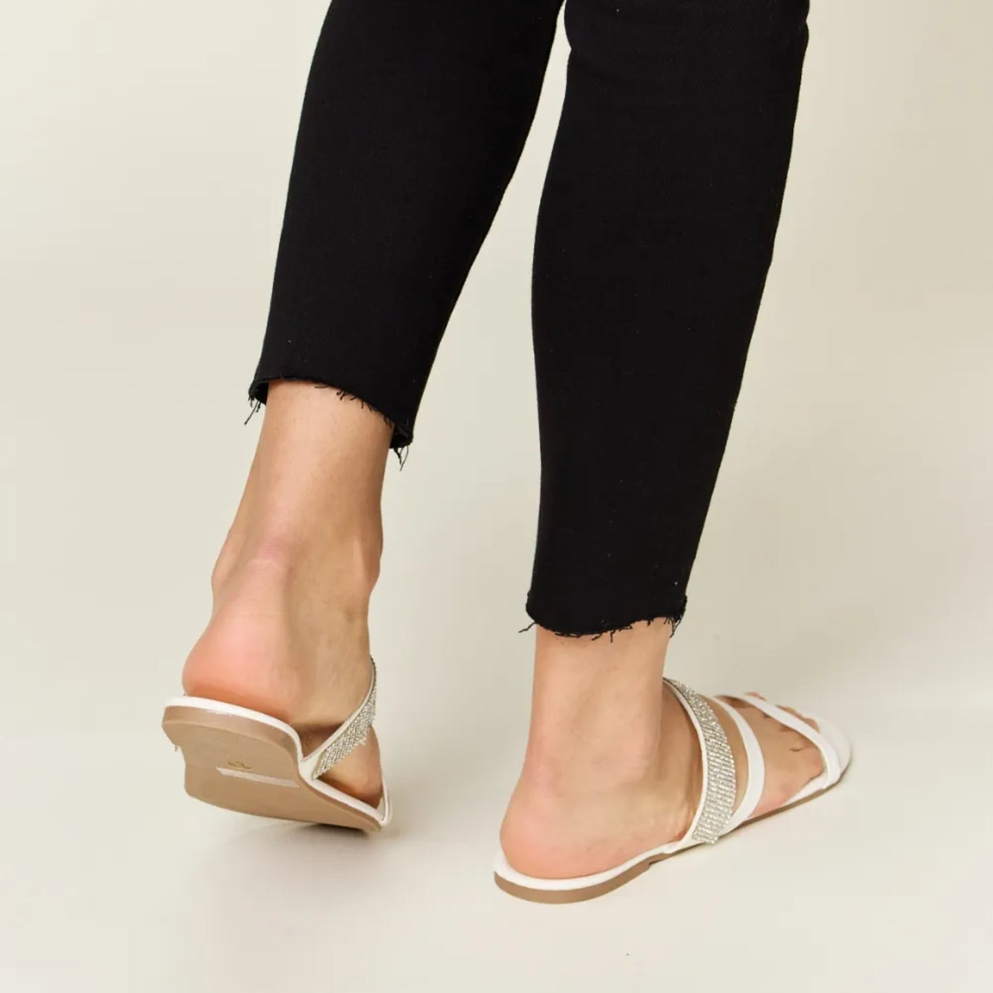 Back view of the low-profile white heel and secure strappy construction.
