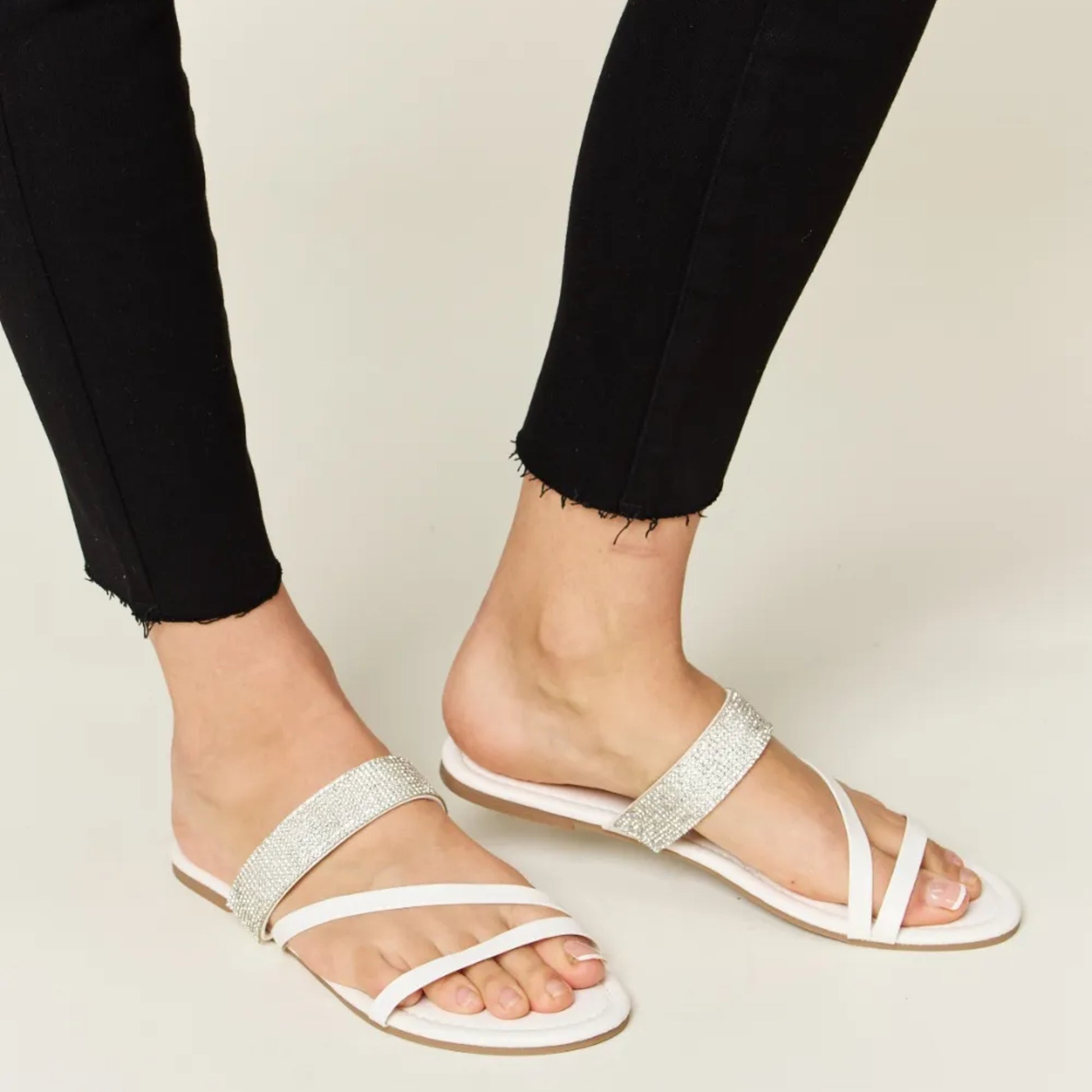 Side profile of white strappy flat sandals showing the 0.4-inch low heel.