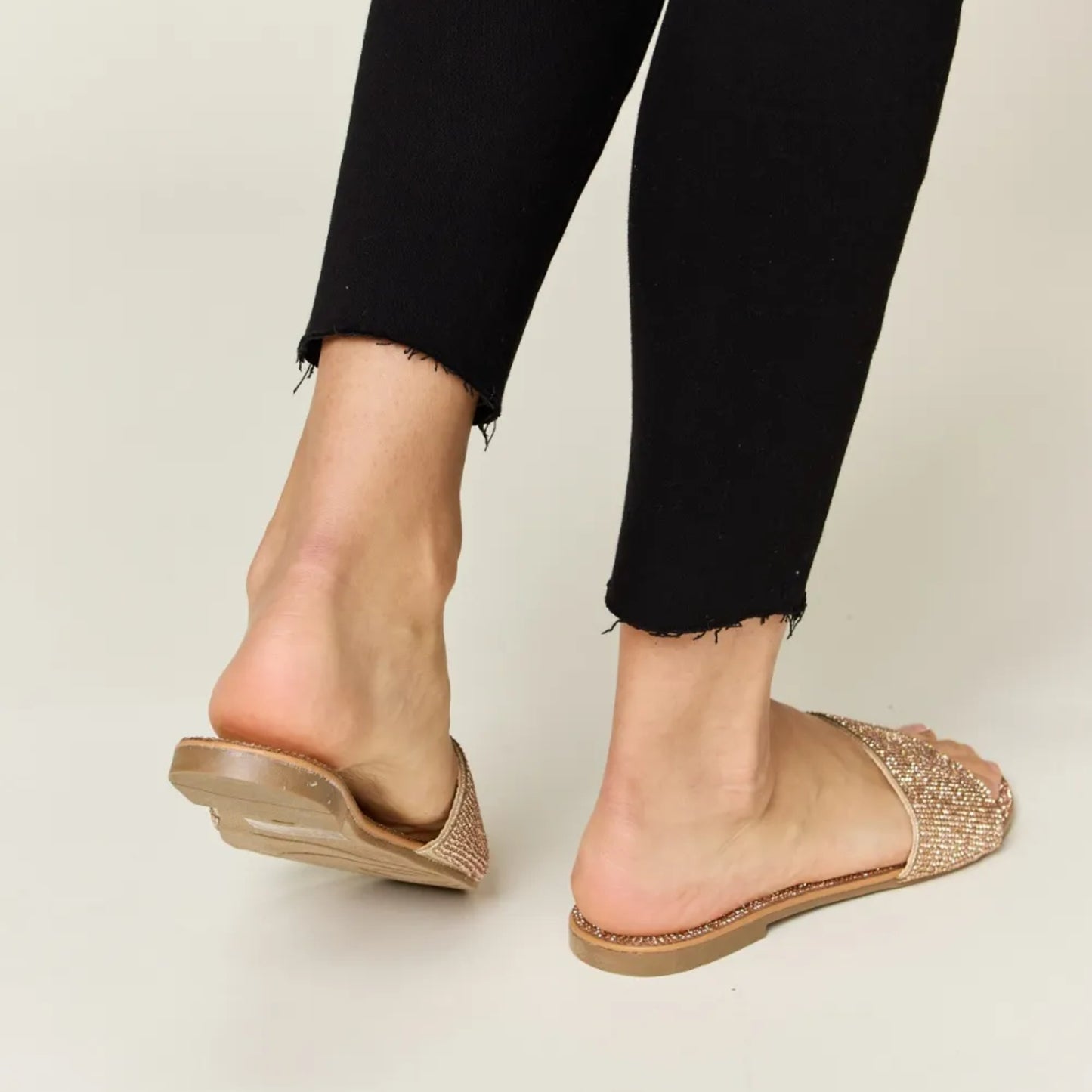 Top-down view of the elegant rose gold footbed and sparkling toe strap.
