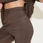 Chocolate textured pants worn by a person on a light background