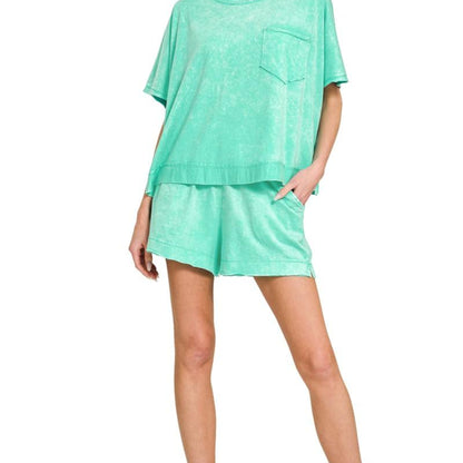 Woman wearing a mint green outfit with a top and shorts on a white background