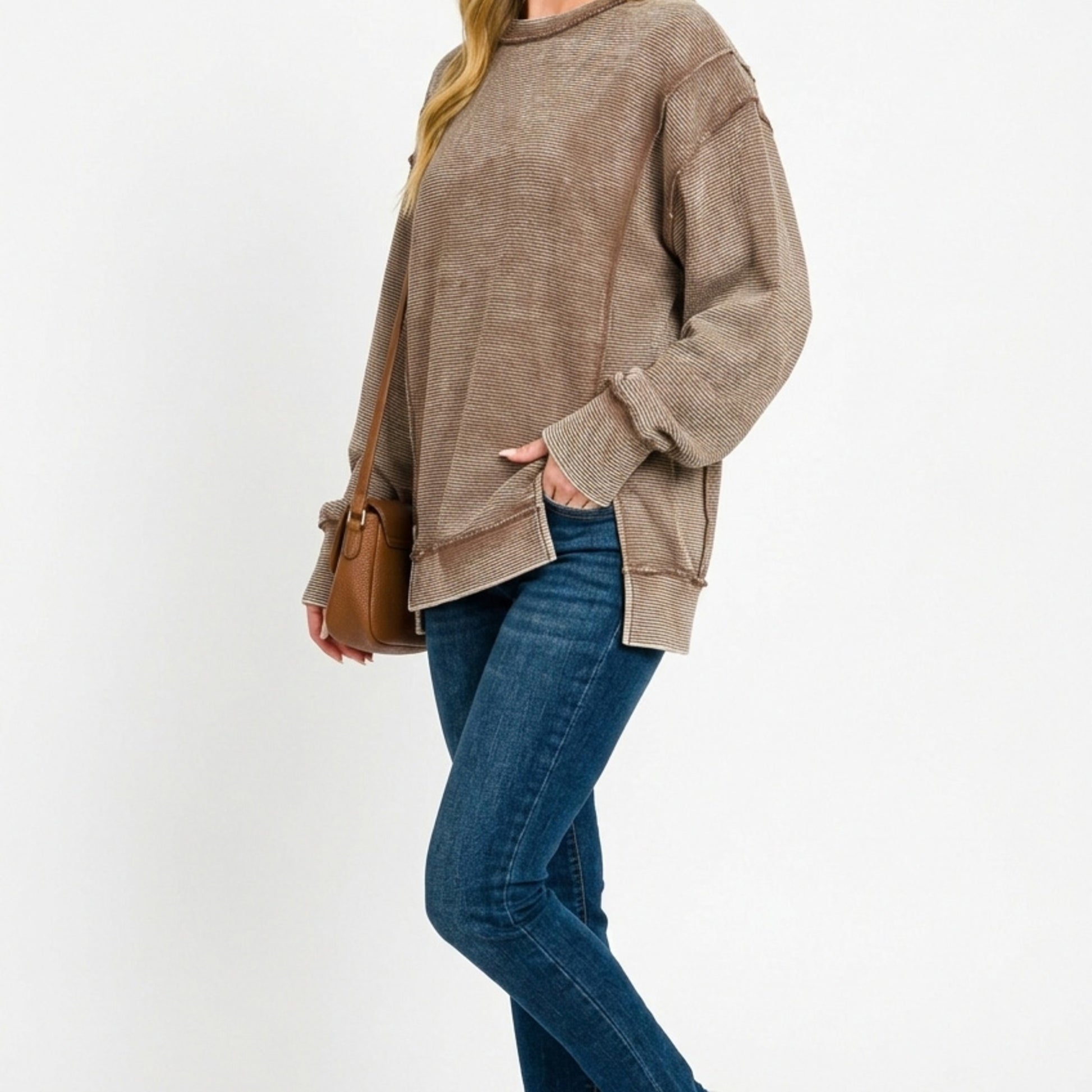 Lifestyle image of the distressed exposed-seam sweatshirt in Brown.
