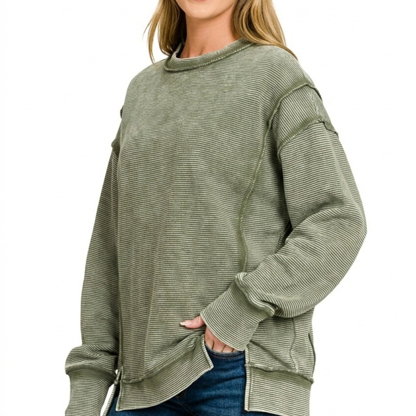 Lifestyle image of the distressed exposed-seam sweatshirt in Dark Olive.